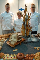 Suomen leipurimaajoukkue valmiiden kilpailutuotteiden äärellä Oslossa. Vasemmalla kahvileipien tekijä Jari Viljamaa, Harjun Leipomo Oy, Kokkola, sitten taitotyöstä vastannut Katri Mäkinen, Elonen Oy Leipomo, Jämsä ja oikealla ruokaleivät leiponut Joachim Wunsch, Fazer Leipomot Oy, Helsinki. 