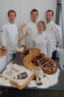 Voittoisa leipurimaajoukkue Katri Mäkisen taitotyön äärellä. Mukana myös valmentaja Veli-Matti Ahvenharju (oik.).